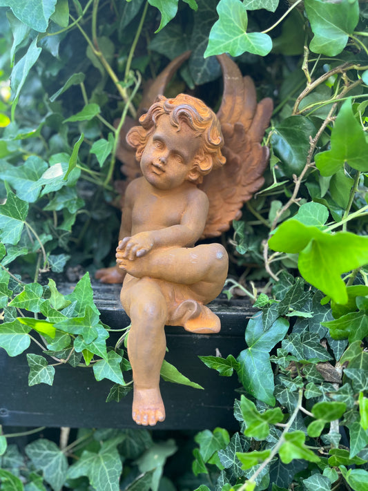 Zittende engel van gietijzer met voet op bovenbeentje - Brocante bij Ingie